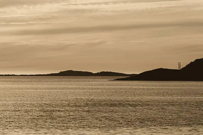 Kveldslys ved Tonnes – Helgeland, rolig hav og lave øyer i varmt gyllent kveldslys.