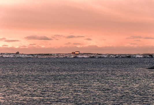 Herøy i gyllent kveldslys, med stille hav og kystlandskap, et veggbilde som gir hjemmet nordnorsk sjarm.