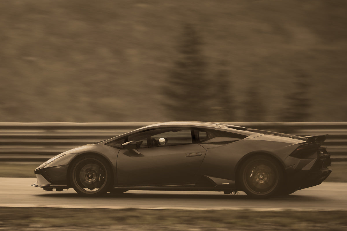 Lamborghini i fart – en sportsbil i høy fart med ikoniske linjer i sepia-toner.