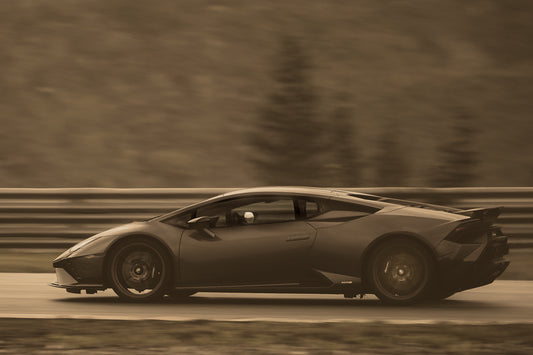 Lamborghini i fart – en sportsbil i høy fart med ikoniske linjer i sepia-toner.