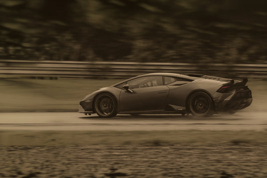 Lamborghini i regnvåt fart – bil i høy fart på våt bane med bevegelsesfølelse og eleganse.