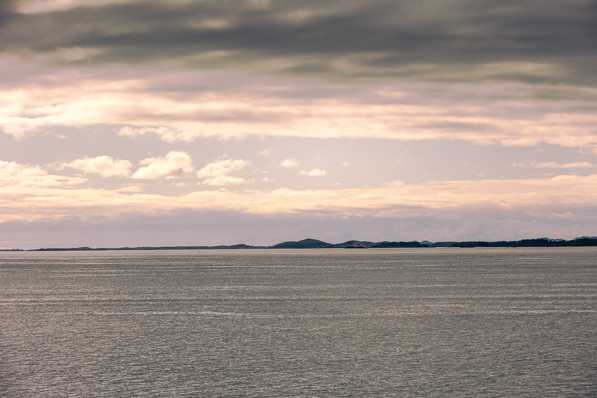 Stillhet over Altenfjorden med åpent hav, lav horisont og myke toner i himmelen.