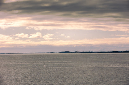 Stillhet over Altenfjorden med åpent hav, lav horisont og myke toner i himmelen.