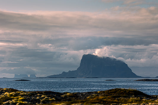 Stemningsfullt bilde av Lovund med Træna i det fjerne, hav og fjell i nordnorsk kystlandskap.