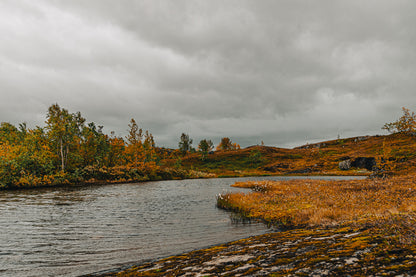 Høststemning i Umskardet, med stille vann, varme høstfarger og dramatisk skydekke i nordnorsk natur.
