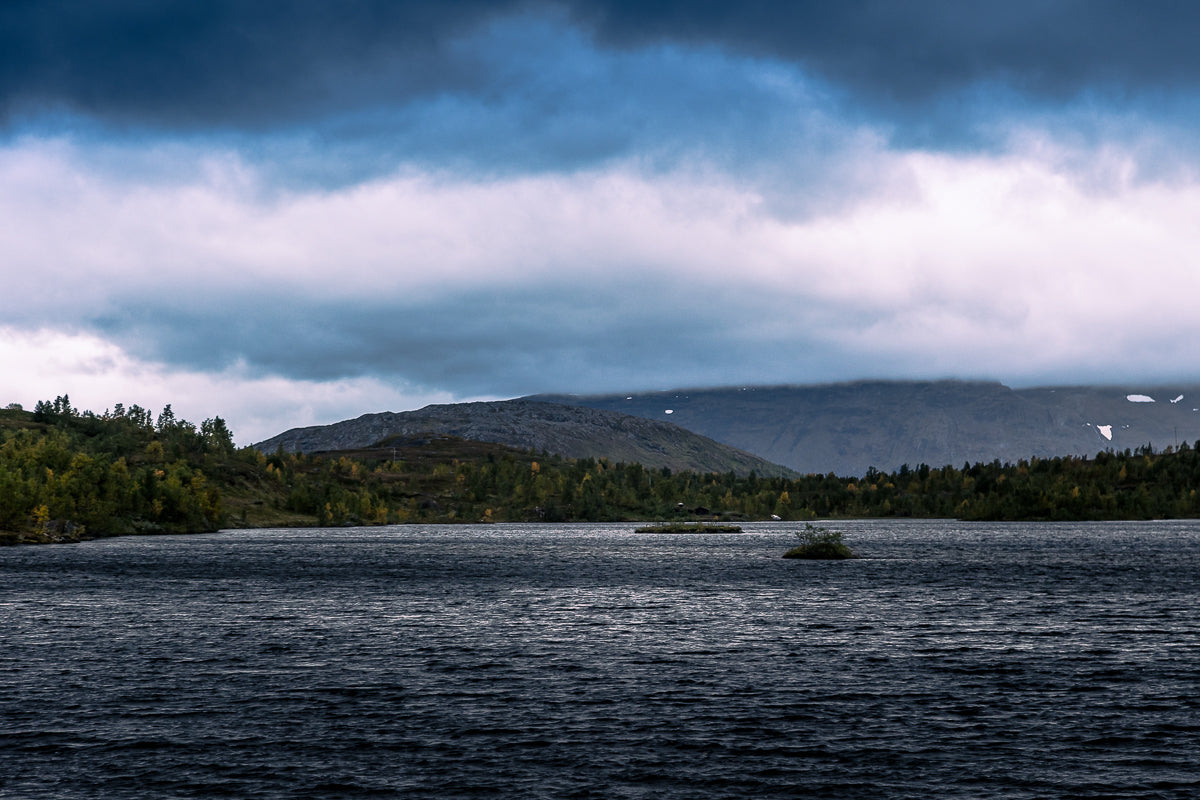 Umskartjønna – dramatisk fjellro med mørkt vann, fjell og dramatisk skydekke i nordnorsk natur.