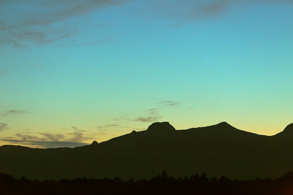 Skumringslys i Utskarpen, mørke fjellsilhuetter mot en rolig himmel i skumringen.
