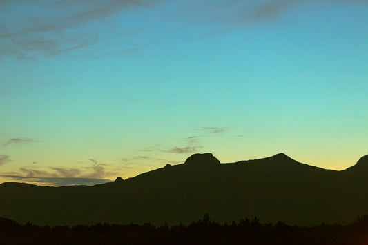 Skumringslys i Utskarpen, mørke fjellsilhuetter mot en rolig himmel i skumringen.