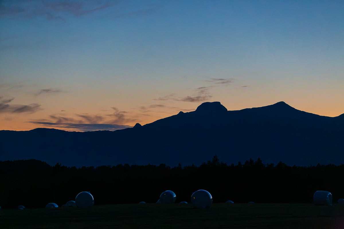 Kveldsro i Utskarpen, veggbilde med mørke fjellsilhuetter mot varm kveldshimmel.