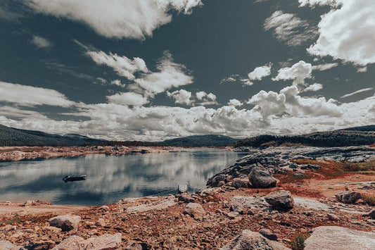Beskrivelse av Storakersvatne, hvor vannflaten speiler skyer og landskap, med nordnorsk natur i bakgrunnen.
