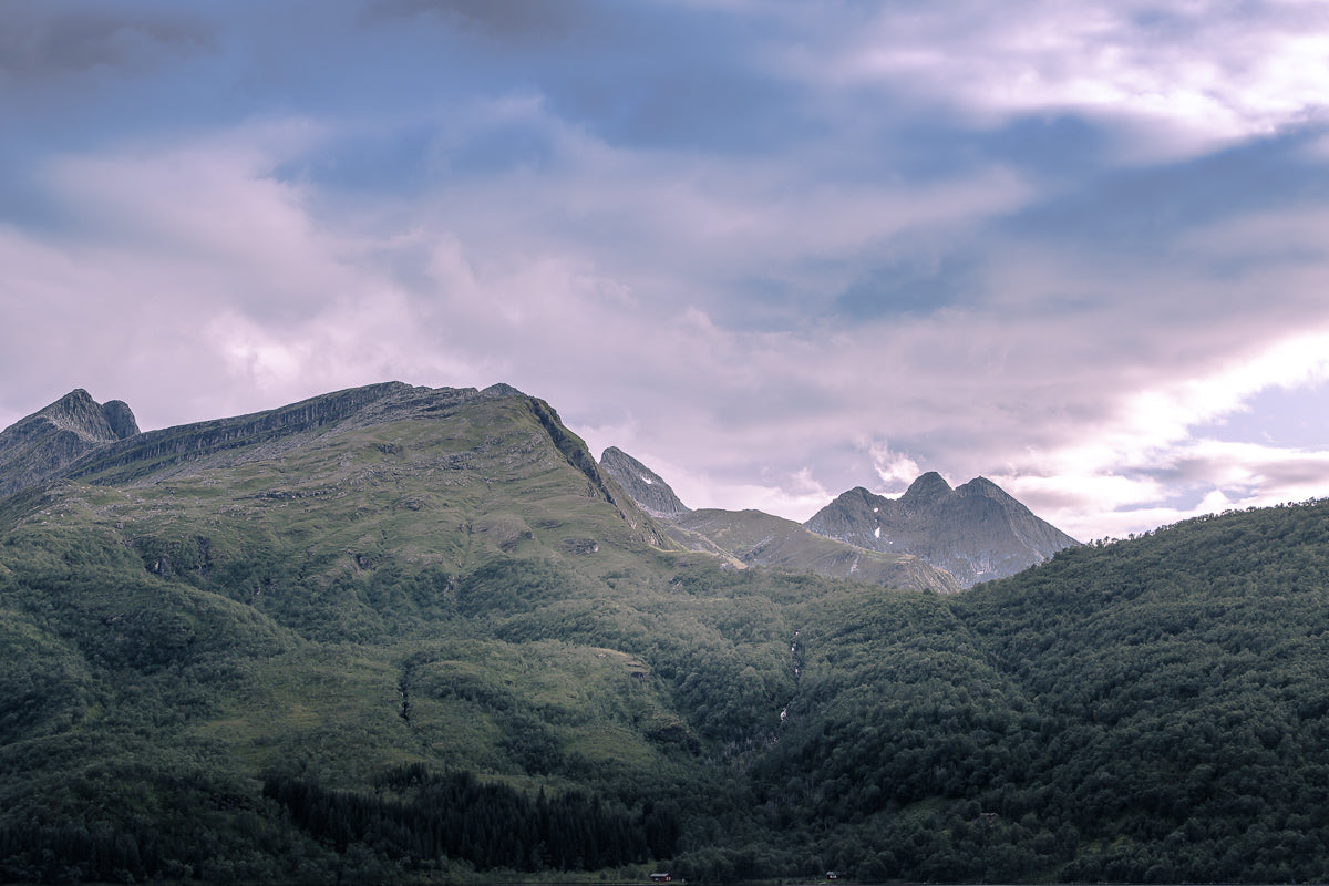 Strandtindan ved Vassvatnet – fjellene omgitt av grønt landskap og dramatisk himmel ved Vassvatnet.