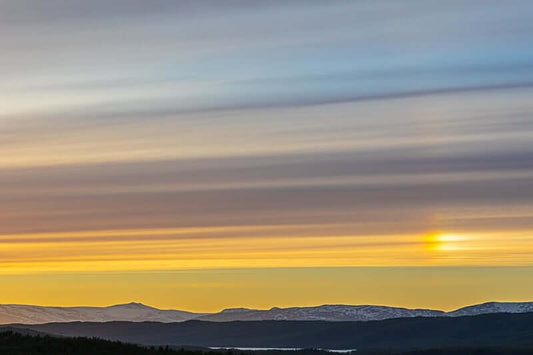 Umbukta landskapsfoto med vakre himmelstriper og sollys over fjellene.
