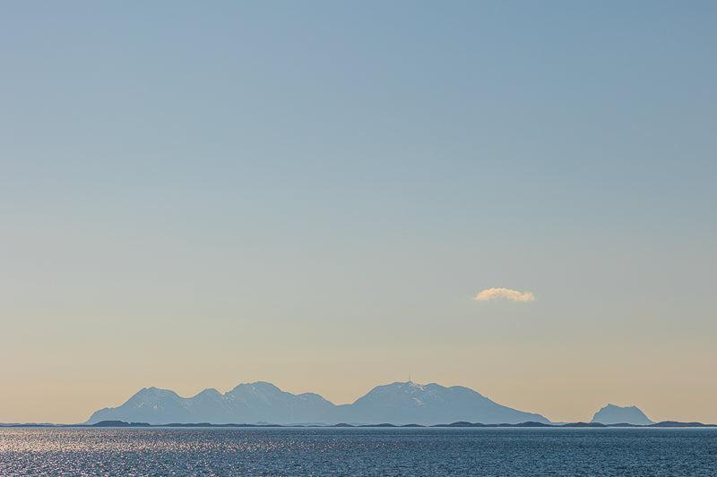 Vega-Helgeland solnedgangsutsikt med fjell i horisonten og speilbilde i havet