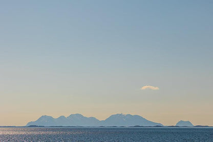 Vega-Helgeland solnedgangsutsikt med fjell i horisonten og speilbilde i havet