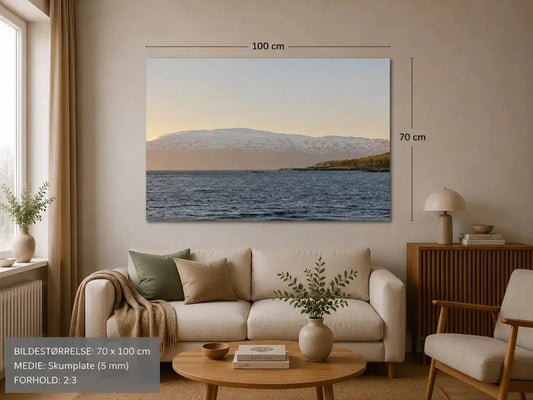 Vinterlys: Tromsø landskap med snødekte fjell og hav, perfekt veggbilde for et nordisk hjem.